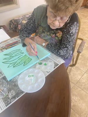 Senior resident painting in an indoor activity space