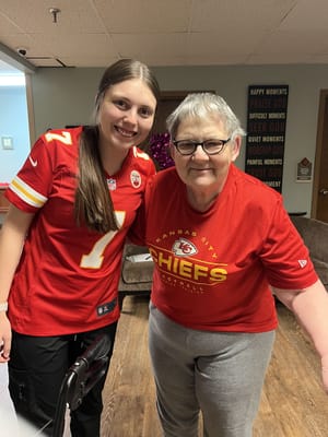A resident and staff member smiling together in the common area