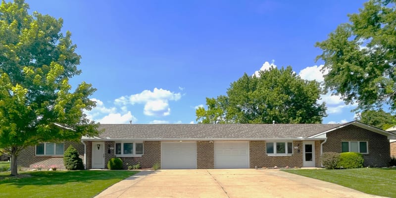 Front view of a senior living facility with outdoor space