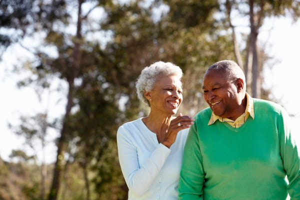 A senior couple smiling together in a garden