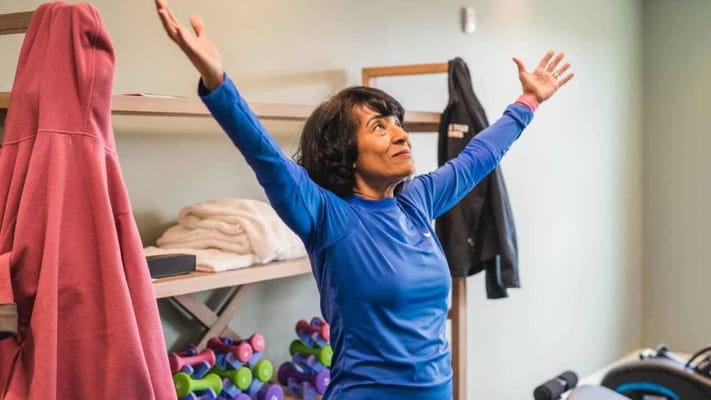 Resident smiling and exercising in an activity room