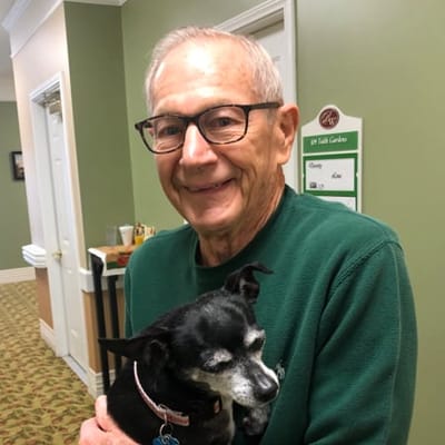 Resident holding a small dog in common area