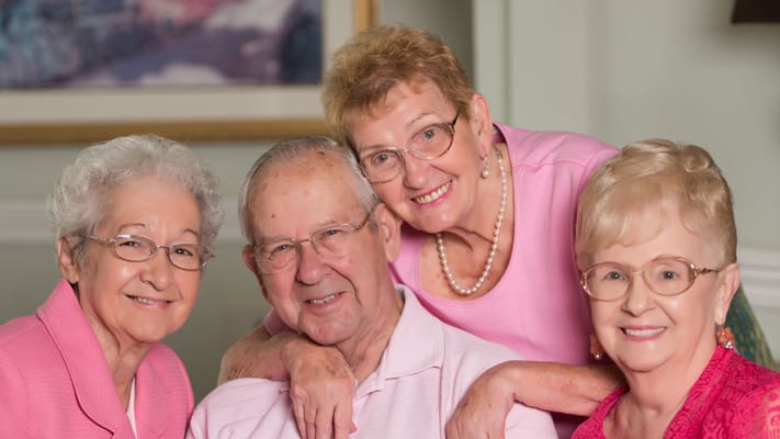 Four residents smiling together in a bright common area