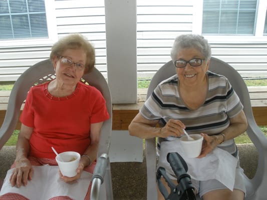 Two residents enjoying ice cream on a porch