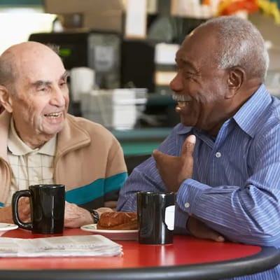 Two senior men enjoying coffee and conversation