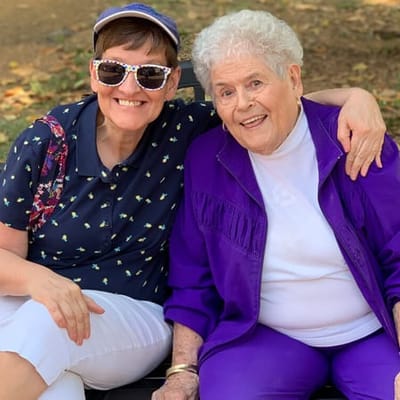 Two women smiling together in a garden