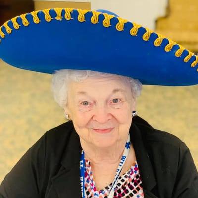 Resident wearing a large sombrero, smiling