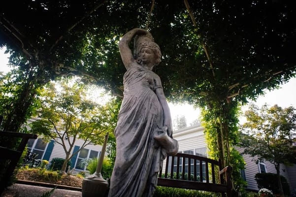 Statue under a gazebo in a garden area