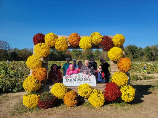 Residents posing in a flower frame at a farm market