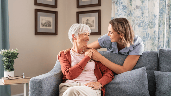 A caregiver interacting warmly with an elderly resident