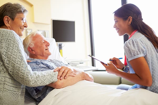 Staff member interacting with two residents in a room