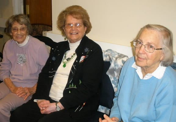 Three elderly women sitting together in a cozy room