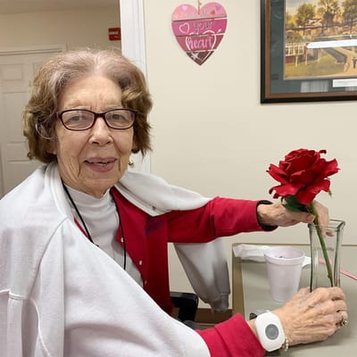 Resident holding a flower in a communal area