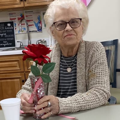 Resident holding a flower vase in the activity room