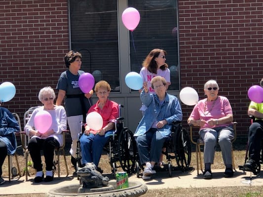 Residents celebrating outdoors with balloons