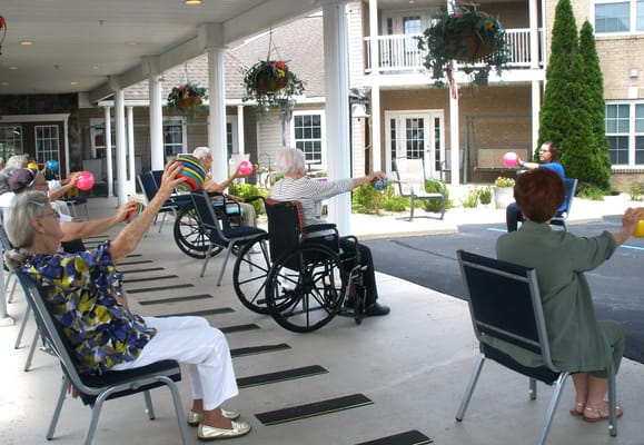Residents participating in a seated exercise class outdoors