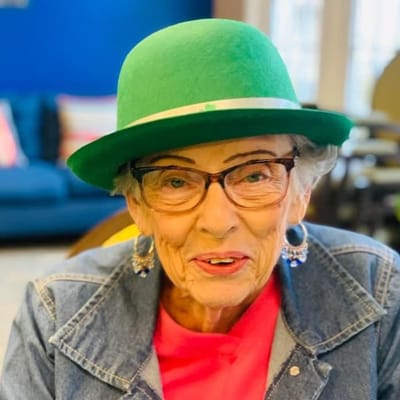 A resident wearing a green hat and glasses