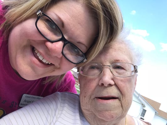 A caregiver and resident smiling together outdoors
