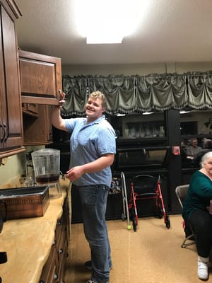 Staff member serving drinks in the facility's kitchen