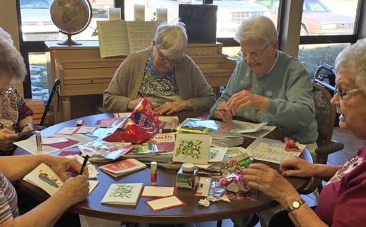 Residents engaged in crafting activity at a common area