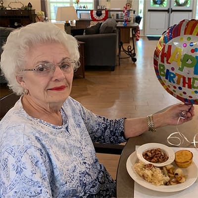 Resident celebrating a birthday with food and a balloon
