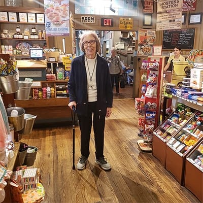 A smiling resident with a cane in a welcoming interior space