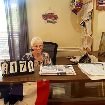 A staff member at the reception desk with a calendar