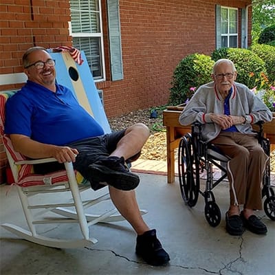 Two residents relaxing on a porch