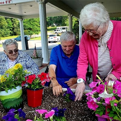 Residents gardening outdoors with colorful flowers