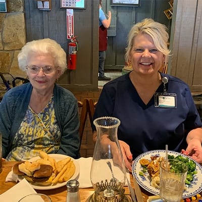 Resident enjoying a meal with staff in the dining area
