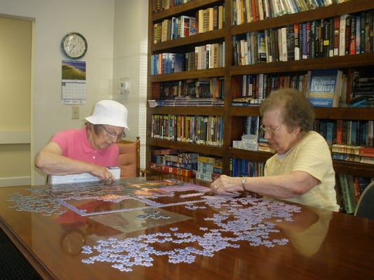 Residents working on a puzzle in a library setting