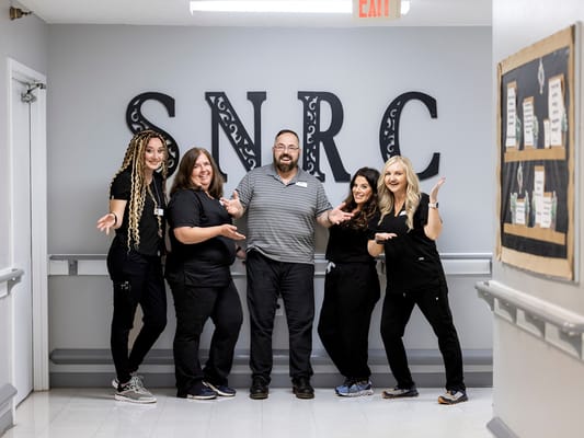 Staff members posing in a hallway
