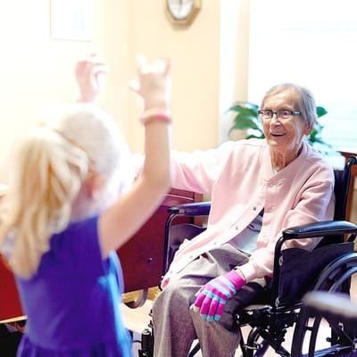 A woman in a wheelchair interacting with a young girl