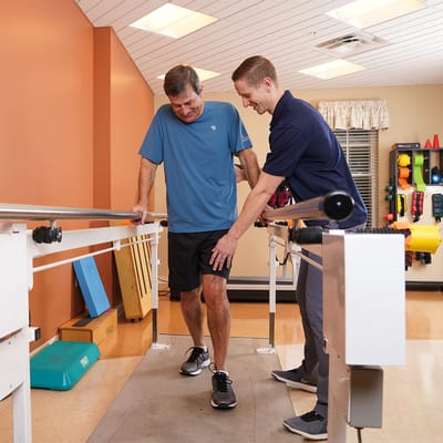 Therapist assisting a resident in a rehabilitation area