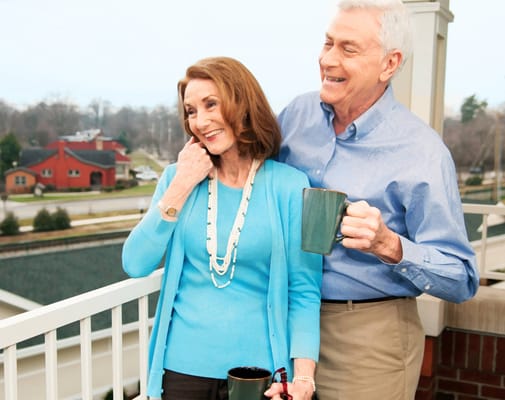 Couple enjoying coffee on a balcony with a view
