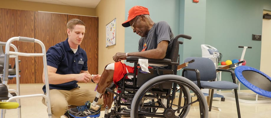 Staff assisting a resident in a wheelchair