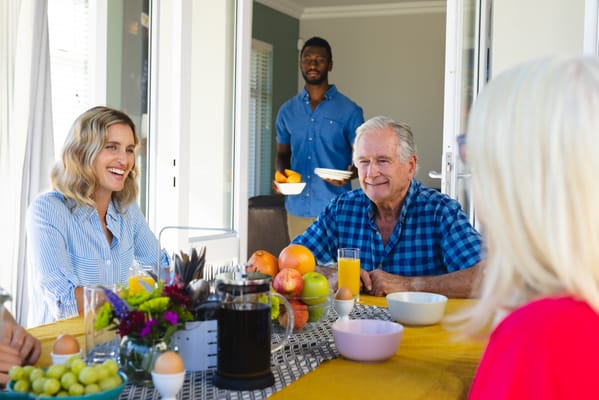 Residents enjoying breakfast with staff in a dining area