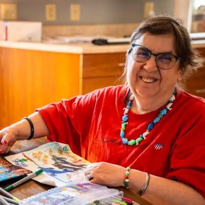 Resident engaging in an art activity while smiling