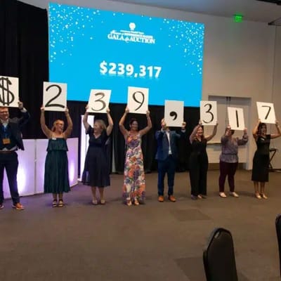Participants celebrating a fundraising total at a gala event