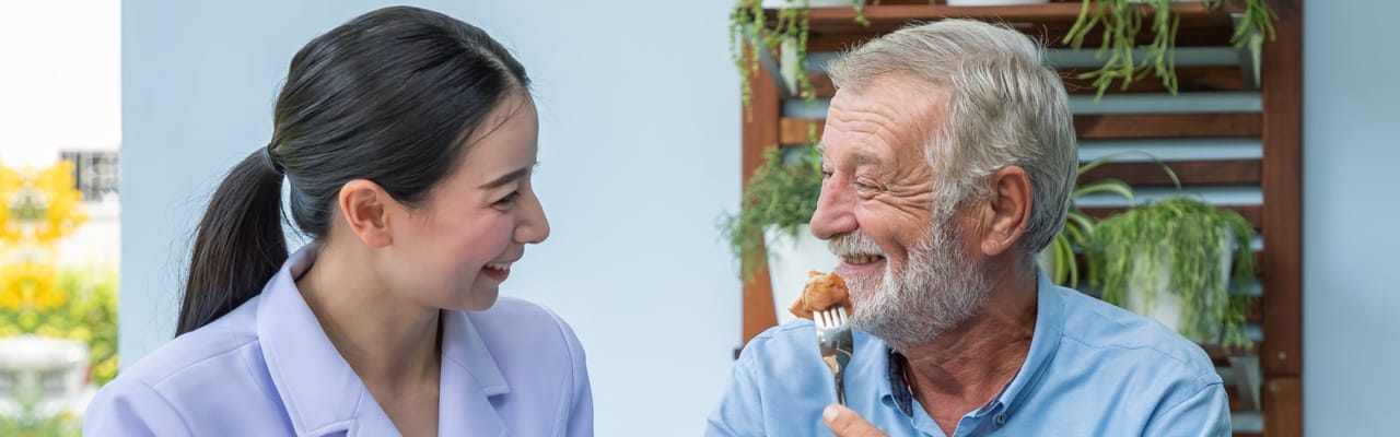 Staff member enjoying a meal with a resident