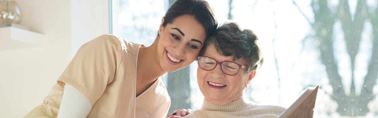 Caregiver and resident enjoying a book together