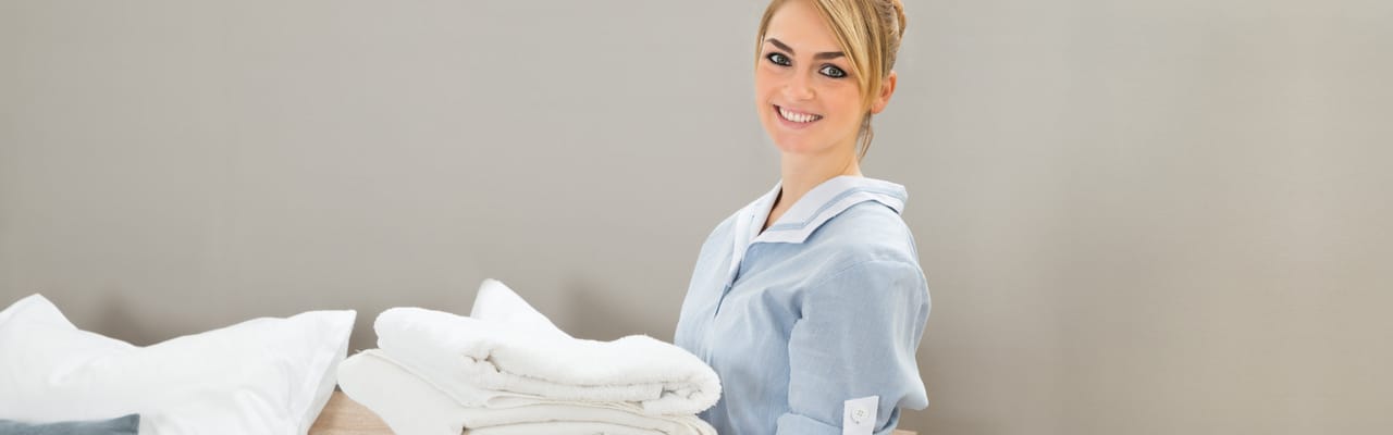 Staff member smiling while holding towels
