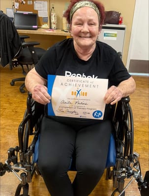 Resident celebrating achievement with certificate