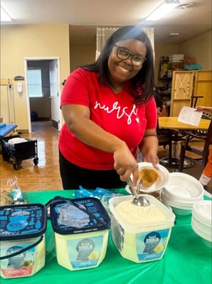 A staff member serving ice cream to residents