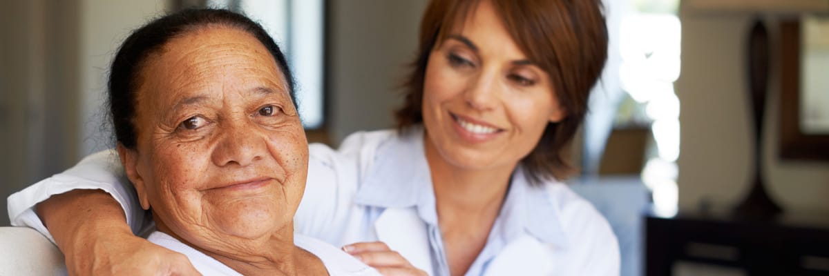 Caregiver smiling with a resident in a lounge setting