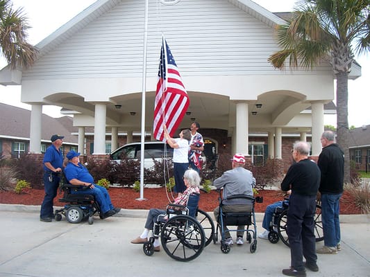 Residents participating in a flag-raising ceremony outside the facility