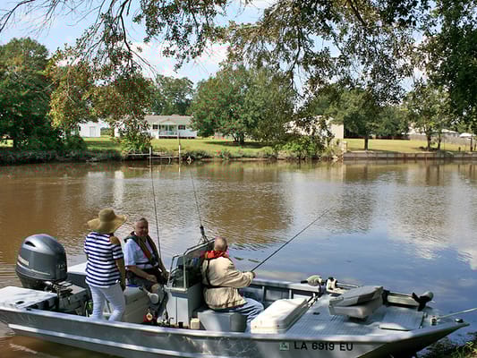 Residents fishing from a boat by a tranquil waterway