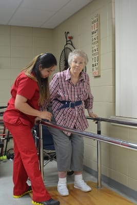 Staff assisting resident with rehabilitation exercise