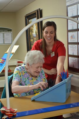 A resident working on a cognitive activity with staff assistance