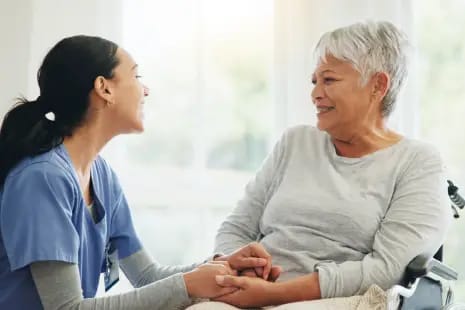 A caregiver and resident smiling during a conversation